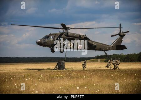 Grafenwöhr, Deutschland - Fallschirmjäger aus 2.BATAILLON, 503Rd Infanterie Regiment, 173Rd Airborne Brigade verhalten Schlinge Ladevorgänge, Transport von Geräten und Fahrzeugen auf Bunker Drop Zone. Stockfoto