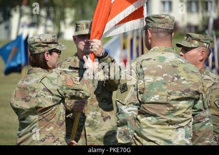 Die 44Th Expeditionary Signal Bataillonskommandeur Oberstleutnant der US-Armee Heather McAteer, Links, leitet die Einheit Farben zu Command Sgt. Maj. Sean S. Mitcham, zweiter von links, während des Bataillon Wechsel der Verantwortung Zeremonie am Turm Kasernen, Grafenwöhr, Deutschland, 27. Juli 2018. Stockfoto