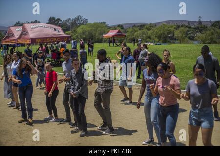 Us-Marines und Segler mit 1 Versorgung Bataillon, Bekämpfung der Logistik Regiment 15, 1 Marine Logistik Gruppe, einen Tanz Wettbewerb mit ihren Familien während einer Familientag in Camp Pendleton, Kalifornien, 26. Juli 2018. Family Day ist eine Veranstaltung, auf der Marinesoldaten und Matrosen dazu ermutigt werden, ihre Familien zu bringen und einen Tag von Veranstaltungen Einheit Zusammenhalt zu errichten. Stockfoto