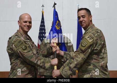 Oberst Scott Gibson, 407 Air Expeditionary Gruppenkommandant und Vorsitzende akzeptiert die 407 Expeditionary Bauingenieur Squadron guidon von Oberstleutnant Glenn Cameron bei einem Befehl Zeremonie an einem geheimen Ort im Südwesten Asien, 27. Juli 2018. Cameron Befehl des Geschwaders zu Maj. Shane Patty aufgegeben. Stockfoto