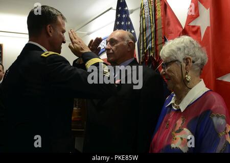 William Gaschler, ein pensionierter Armeveteran, begleitet von seiner Frau, Karla Gaschler, Austausch ein Gruß mit Generalmajor Michael E. Kurilla, Kommandierender General der 82nd Airborne Division, während eine Bronze Star Medal mit Valor Preisverleihung auf Fort Bragg, N.C., 28. Juli 2018. Gaschler war für die Rettung von zwei fallschirmjäger anerkannt, 13. Mai 1965, beim Dienen als Scharfschütze team leader mit Firma A, 1st Battalion, 504Th Parachute Infantry Regiment, 82nd Abn. Div., während der Operation Power Pack in der Dominikanischen Republik. Stockfoto