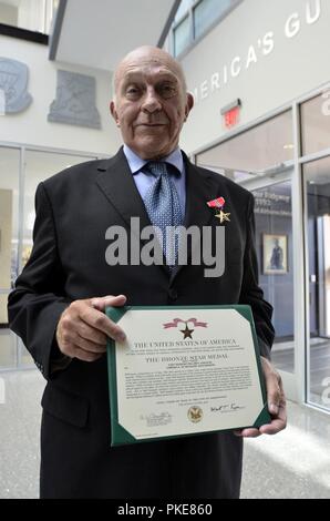 William Gaschler, pensionierter Army Veteran, hält seine Bronze Star Medal mit Valor Zertifikat an der 82nd Airborne Division das Hauptquartier von Fort Bragg, N.C., 28. Juli 2018. Gaschler erhielt die Auszeichnung für die Rettung von zwei fallschirmjäger Mai 13, 1965, beim Dienen als Scharfschütze team leader mit Firma A, 1st Battalion, 504Th Parachute Infantry Regiment, 82nd Abn. Div., während der Operation Power Pack in der Dominikanischen Republik. Stockfoto