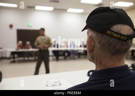 Ein Mitglied der Vietnam Veterans of America (VVA), hört sich die US Marine Corps Oberst Raul Lianez, kommandierender Offizier, Marine Corps Base Hawaii (MCBH), bei einem Treffen mit der VVA, Oahu Kapitel, umreißt MCBH's Mission und Richtung, Honolulu, 28. Juli 2018. Die Vva besteht aus mehr als 160 Mitgliedern in Hawaii, hilft Veteranen, Gemeinschaften, und jene, die in Gefahr. Stockfoto