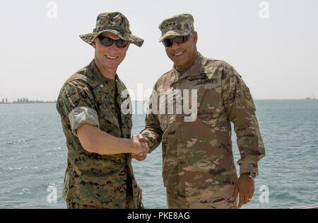 Us-Armee Generalleutnant Michael X. Garrett, US-Army Central Commander, posiert für ein Foto mit US Marine Corps Oberstleutnant Scott Westerfield, U.S. Navy/U.S. Marine Corps Attaché, US-Botschaft, Oman, nach, indem Sie ihn mit einer Münze im Hafen von Duqm, Oman, 25. Juli 2018. Generalleutnant Garrett besuchte den Hafen zu beurteilen, es ist Fähigkeit, dauerhafte USARCENT Zusammenarbeit in der Region unterstützen. Stockfoto
