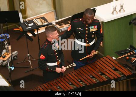 Us Marine Corps Lance Cpl. Thomas J. Maurer, Links, Musiker, Marine Corps Base Quantico (MCBQ) Band, und Gunnery Sgt. Douglas J. Hardee, Musiker, MCBQ Band, interagieren, während eines Konzerts im Mantyharju Kirche, Mantyharju, Finnland, 29. Juli 2018. Die MCBQ Band weiterhin an verschiedenen Orten rund um Finnland durchzuführen, da Sie für die 2018 Hamina Tattoo vorbereiten. Stockfoto