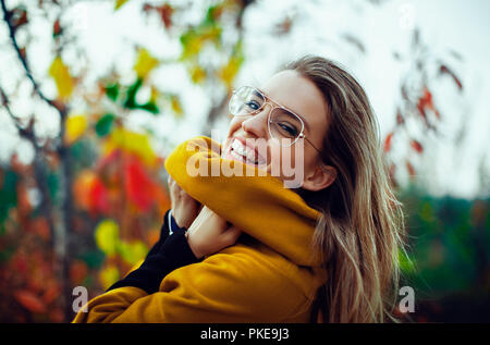 Frau Lächeln im Herbst mit Blättern Stockfoto