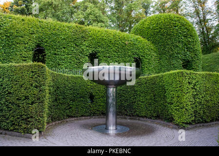 Coanda Wasserspiel in der Schlange in der Nähe von Alnwick Garten. Hainbuche Hedging mit 'Windows' hinter; Alnwick, Northumberland, England Stockfoto