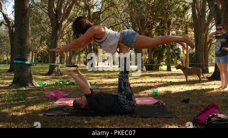 Junge Frauen, die das Üben acro Yoga in einem öffentlichen Park in Florida, Jupiter, Florida. USA - Juni 17., 2017. Stockfoto