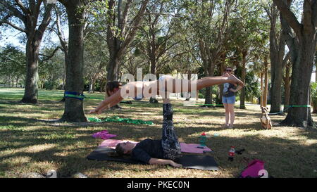 Junge Frauen, die das Üben acro Yoga in einem öffentlichen Park in Florida, Jupiter, Florida. USA - Juni 17., 2017. Stockfoto