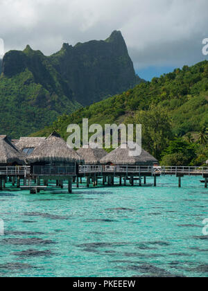 Über das Wasser Bungalows im Hilton Lagoon Resort und Spa, Papetoai, Moorea, Tahiti, Französisch-Polynesien Stockfoto