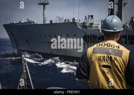 Meer (Aug. 3, 2018) ein Matrose überwacht eine im Gange der Nachschub zwischen der Arleigh-Burke-Klasse geführte Anti-raketen-Zerstörer USS Carney (DDG64) und die militärische Sealift Command schnell - combat Support ship USNS Leroy Grumman (T-AOE 195) August 3, 2018. Carney, Vorwärts - Rota, Spanien eingesetzt, ist über seine fünfte Patrouille in den USA 6 Flotte Bereich der Maßnahmen zur Unterstützung der regionalen Verbündeten und Partnern sowie die nationale Sicherheit der USA Interessen in Europa und Afrika. Stockfoto