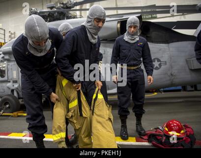 Atlantik (Aug. 6, 2018) Midshipman 2. Klasse Trevor Stutzman, Mitte, von Charlottesville, Virginia, zieht die Brandbekämpfung Ausrüstung während einer General Quarters Bohrers, während Sie an Bord der Flugzeugträger USS George H.W. eingeleitet Bush (CVN 77). Das Schiff ist im Gange, die Durchführung von routinemäßigen Übungen Träger bereit zu halten. Stockfoto