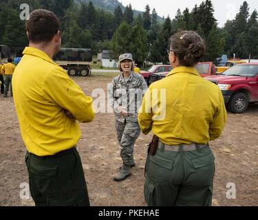 Kol. Lisa McLeod, der Kommandant der 141. Instandhaltungsgruppe, lacht mit Wachposten aus der 141 Luftbetankung Flügel, während die Schafe Creek fire Camp in Northport, Washington August 8, 2018 zu besuchen. Fast 200 Luft- und Armee Nationalgarde wurden mobilisiert, um Hilfe bei der Brandbekämpfung in Washington staatliche Beihilfen. Stockfoto