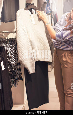 Junge Frau stylist Shopper wählt Kleidung im Store. Stockfoto