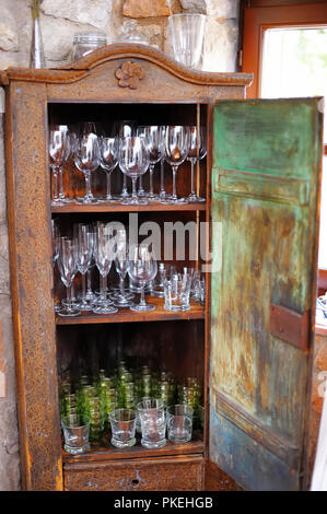 Verschiedene Gläser und Ausstattung der Küche im alten Landhausstil stil Holzschrank. Stockfoto