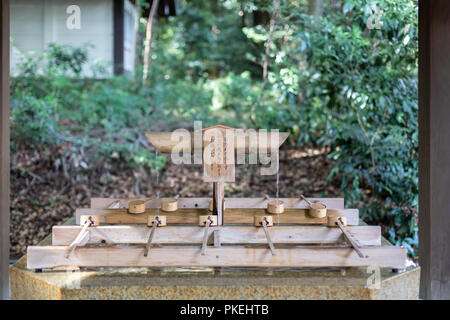 Ein Brunnen mit Bambus Schöpfkellen für ein Ritual der Reinigung vor dem Betreten der Meiji Schrein in Tokio Stockfoto