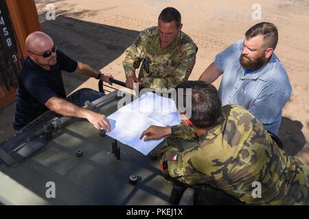 Paul Lewis, Links, Chief Training Support Teams und Bobby Lightner, zweite rechts, eine Auswahl und Ausbildung Land Programm Manager, beide mit der US Army Training Support Aktivität Europa (TSAE) sprechen Sie mit Soldaten aus Tschechien und den Niederlanden nach einem Probelauf in einem neu gebauten Tank in Pabrade, Litauen, Nov. 09, 2018. TSAE führte eine Endabnahme der Anlage als TSAE ist Unterstützung von NATO-Verbündeten in Osteuropa entwickeln ihre Auswahl und Ausbildung Infrastrukturen. Stockfoto