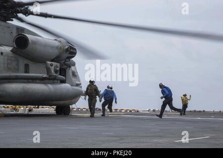 MINDANAO MEER - U.S. Navy Segler und US-Marines mit der Essex Amphibious Ready Group (ARG) und dem 13 Marine Expeditionary Unit (MEU) Ein CH-53E Super Stallion vorbereiten mit Marine Medium Tiltrotor Squadron 166 verstärkt, 13 Marine Expeditionary Unit (MEU), zum Abflug an Bord der Wasp-Klasse amphibisches Schiff USS Essex (LL 2) während der Durchführung von Such- und Rettungsaktionen während einer planmäßigen Einsatz der Essex ARG und 13. MEU, 11. August 2018. Das Essex ARG/13 MEU ist derzeit auf dem Siebten Flotte Bereich der Operationen eingesetzt. (U. Us Marine Corps Stockfoto