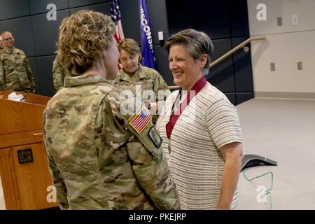 Brig. Gen. Joni Mathews, stellvertretender in Wisconsin Adjutant General für Armee, präsentiert pensionierten Oberst Leah Moore, eine Armee Medical Officer und ehemaligen Joint Stabschef für die Wisconsin National Guard, der mit einer Medaille, was bedeutet, dass sie in der Reihenfolge der militärischen medizinischen Verdienste bei einer überraschung Zeremonie Aug 3 eingesetzt wurde in Witmer Halle an der gemeinsamen Kraft Hauptsitz in Madison, Wis. Wisconsin nationalen Schutz Stockfoto