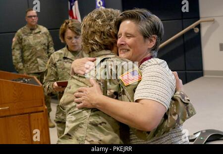 Brig. Gen. Joni Mathews, stellvertretender in Wisconsin Adjutant General für Armee, gratuliert Oberst Leah Moore, eine Armee Medical Officer und ehemaligen Joint Stabschef für die Wisconsin National Guard, der auf ihrer Induktion in der Reihenfolge der militärischen medizinischen Verdienste bei einer überraschung Zeremonie Aug 3 in Witmer Halle an der gemeinsamen Kraft Hauptsitz in Madison, Wis. Wisconsin nationalen Schutz zurückgezogen Stockfoto