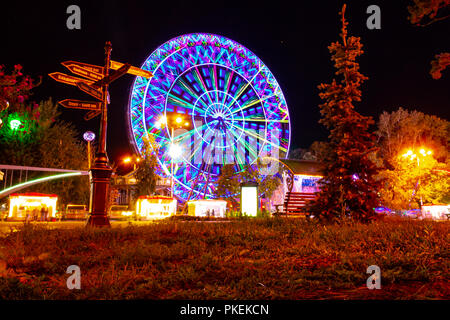 Riesenrad am Ufer des Amur in Chabarowsk gegen den Nachthimmel. Eine helle Beleuchtung. An der langen Belichtung fotografiert. Stockfoto