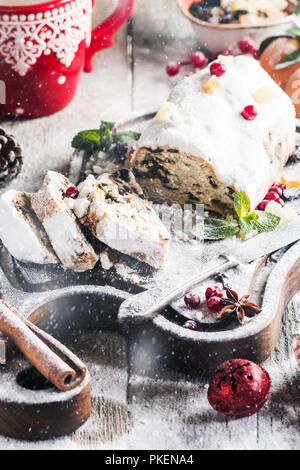 Christstollen, traditionelle deutsche, europäische festliches Dessert in Stücke geschnitten auf Holz- Hintergrund. Stockfoto