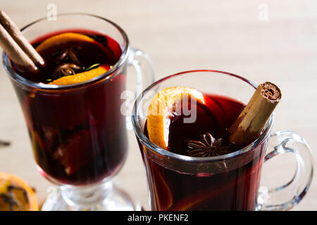 Glühwein im Glas mit Würze und Frucht auf Holztisch. Stockfoto