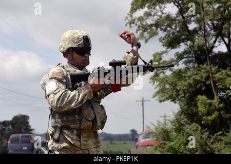 Spc. Gerald Villamar, ein Signal Intelligence Analyst der 629th Auslandseinsätze der Bundeswehr Maryland Army National Guard Intelligence Battalion, 58th Expeditionary Military Intelligence Brigade, feuert eine Runde aus einem M4-Sturmgewehr während der drei gun Stress schießen Teil der 2018 Army National Guard besten Krieger Wettbewerb am Fort Indiantown Gap, Pennsylvania, 26. Juli 2018. Villamar ist eines von 14 Soldaten, die im Falle konkurrieren, in der Hoffnung, genannt zu Army Guard Soldat des Jahres. ( Stockfoto