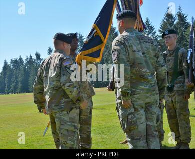 Oberstleutnant Donald R. Neal Jr., der Kommandant der 1.Bataillon, 17 Infanterie Regiment, akzeptiert das Gerät Handbuch, das sich auf von Col. Jay Miseli, der Kommandant der 2. Stryker Brigade Combat Team, was bedeutet, dass seine Annahme der Befehl von Oberstleutnant Matt Rasmussen während des Bataillon Ändern des Befehls Zeremonie am Watkins Feld am Joint Base Lewis-McChord, Washington, 26. Juli 2018. "Ich möchte, dass ihr wisst, dass ich bin unglaublich gedemütigt und geehrt die Büffel wieder zu dienen", sagt Neal. Stockfoto