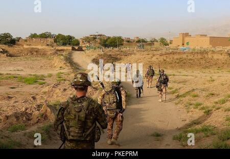 Raider Soldaten aus dem 4., 9. Bataillon der Infanterie Regiment, 1 Stryker Brigade Combat Team, 4 Infanterie Division und Soldaten aus der tschechischen Armee Verhalten einer Patrouille im östlichen Afghanistan mit Einheimische zu treffen und Informationen über Bedrohungen in der Umgebung sammeln, 25. Juli 2018. Stockfoto