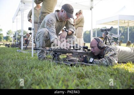 Coast Guard Petty Officer 1st Class Eric Maurer, eine maritime Durchsetzung Spezialist und ein Ausbilder mit der Präzision Treffsicherheit Schule, Tests das Absehen von Petty Officer 1st Class Chris Roberts M 110 Halbautomatische Sniper System, indem Sie seine Hand vor der Anwendungsbereich während der Präzision Treffsicherheit Kurs an der spartanischen Ranch Tactical Training Center, Maysville, Juli 26. Nach Abschluss des vierwöchigen Kurs, der coastguardsmen wird Präzision sportschützen angesehen werden können und die Fähigkeiten, die Sie in das Feld Job gelernt. Stockfoto