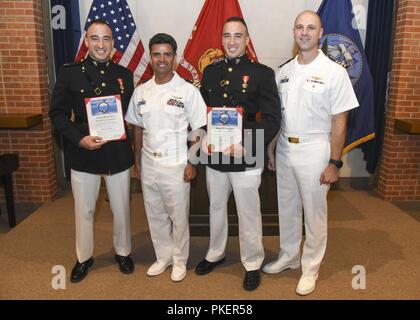 Fräulein (Juli 27, 2018) Marine Corps Kapitän Matteo Occhipinti, Links, Cmdr. Steven Vitrella, kommandierender Offizier der Training Squadron (VT) (7, 1 Leutnant Andrea Occhipinti und US-Marine Kapitän Nicholas Mungas, Commodore der Ausbildung Air Wing (CNATRA) 1, für ein Gruppenfoto posieren vor dem Twin Occhipinti Brüder gleichzeitig ihr Gold aviator Wings während einer wilden Feier in der Kapelle des Naval Air Station Meridian, Fräulein, 27. Juli 2018 erhalten. Die Brüder abgeschlossen Erweiterte Jet Flug Training mit Training Squadron sieben. Stockfoto