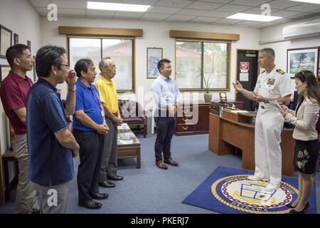 OKINAWA, Japan (1. August 2018) Kapitän Robert Mathewson (rechts), Commander, Flotte Aktivitäten von Okinawa, erfüllt mit dem Bürgermeister und der Beamten von den Daisen Stadt in der Präfektur Tottori und der Bürgermeister von Kadena Stadt im Commander Flotte Aktivitäten Okinawa (Cfao) Hauptquartier während einer Tour von Cfao. Daisen und Kadena Städte engagieren sich in verschiedenen Exchange Aktivitäten, und die Beamten nahmen sich die Zeit, während dieser Reise zu den Einrichtungen, die Tour und über die Marine Präsenz in Okinawa lernen. Stockfoto