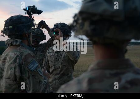 Us-Fallschirmjäger in den zweiten Bataillon zugeordnet, 503Rd Infanterie Regiment, 173Rd Airborne Brigade für Schlinge legen Verfahren für mit einer CH-47 F Chinook Helicopter Bravo Company, 1 Battalion, 214Th Aviation Regiment, 12 Combat Aviation Brigade zugewiesen an der 7th Army Training Befehl Grafenwöhr Training Area, Deutschland, 27. Juli 2018 vorbereiten. Stockfoto