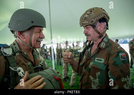 Südafrikanische Fallschirmjäger Kapitän Tienie van Schoor bietet eine Faust bump zu Generalmajor Shai Mulder während nachhaltige Airborne Training als Teil der Leapfest an der Universität von Rhode Island, West Kingston, R.I., 31. Juli 2018. Leapfest ist der größte und am längsten bestehende, internationale statische Linie Fallschirm Training und Wettbewerb veranstaltet vom 56. Truppe den Befehl, Rhode-Island Army National Guard hohen Niveau zu fördern technische und Korpsgeist innerhalb der internationalen Gemeinschaft in der Luft. Stockfoto