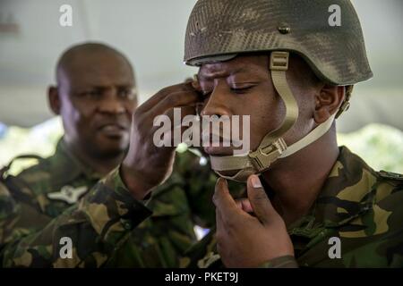 Botswana Fallschirmjäger Lance Cpl. Matsoga hält seine Kinnriemen als Warrant Officer II Thebe, ein jumpmaster mit der Botswana Militär, zieht seinen Helm während nachhaltige Airborne Training als Teil der Leapfest an der Universität von Rhode Island, West Kingston, R.I., 31. Juli 2018. Leapfest ist der größte und am längsten bestehende, internationale statische Linie Fallschirm Training und Wettbewerb veranstaltet vom 56. Truppe den Befehl, Rhode-Island Army National Guard hohen Niveau zu fördern technische und Korpsgeist innerhalb der internationalen Gemeinschaft in der Luft. Stockfoto