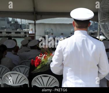 NORFOLK, Virginia (Aug. 1, 2018) ein Navy Officer halten Blumen, während das U-Boot Squadron 6 Ändern des Befehls an Bord der Virginia zu einem Familienmitglied vorgestellt werden - Klasse Angriffs-U-Boot USS Washington (SSN787) in Norfolk, Virginia. Kapitän Martin Muckian entlastet Kapitän Carl Hartsfield als Kommandant, Submarine Squadron Six. Stockfoto