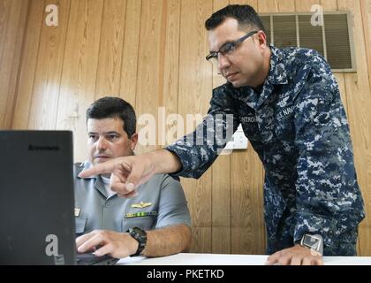 MAYPORT, Fla (Aug. 01, 2018) - Elektroniker 2. Klasse Alvin Cintron und brasilianische Kapitän Leandro Demitrio, das Maritime Operations Center Direktor, arbeiten zusammen in der Vorbereitung für PANAMAX 2018. Die Übung ist auf die Sicherheit der Panamakanal und die Stabilität innerhalb des US Southern Command Verantwortungsbereich konzentriert. Stockfoto