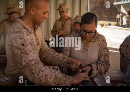 Unbekannten ORT, NAHER OSTEN - US Marine Corps Cpl. Colton Lefor (links), eine Bekämpfung der Ingenieur, und Cpl. Priscilla Jimenez (rechts), ein Kraftfahrzeug Fahrer mit der Bekämpfung der logistischen Abteilung 37 Special Purpose Marine Air-Ground Task Force angebracht, Krise Response-Central Befehl, bereiten Sie ein Wasser kostenlos vor Ausführung eines Abbruch während der Übung Glück Seepferdchen 27. Juli 2018. Die Marines praktiziert verschiedene Ebenen des Referenzwerts, eine wichtige Fähigkeit in urbanen Kriegsführung Umgebungen verwendet. Stockfoto