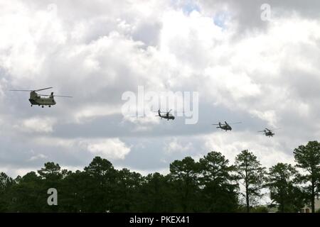 Eine CH-47 Chinook, zwei AH-64 Apache und ein UH-60 Blackhawk Hubschrauber fliegen Overhead während der 82Nd Airborne Division Ändern des Befehls Zeremonie am Pike Feld in Fort Bragg, North Carolina, Aug 2, 2018. Die Zeremonie geehrt US-Armee Generalmajor Michael Kurilla, der scheidende Division kommandierender General, und begrüßte Generalmajor James Mingus, die eingehenden kommandierenden General. Stockfoto