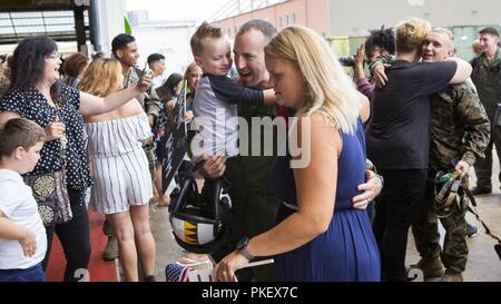 Us Marine Kapitän Paul Lindholm Umarmungen seiner Familie nach der Rückkehr nach Hause von sieben - Monat Bereitstellung mit dem 26 Marine Expeditionary Unit (MEU) bei Marine Corps Air Station Cherry Point, N.C., am Aug 2, 2018. Marines wurden von Familien, Freunden und Lieben zu den VMA-542 Hangar. Lindholm ist ein Pilotprojekt mit VMA-542. Stockfoto