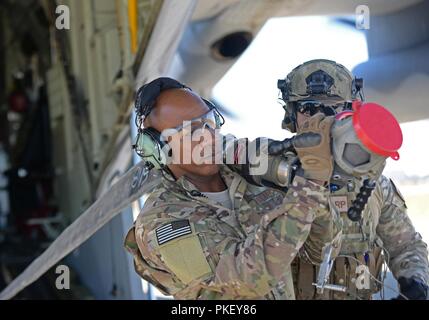 Chief Master Sgt. der Air Force Kaleth O. Wright trägt eine kraftstoffschlauch von einem MC-130J II Commando während einer vorderen Bereich Tanken Punkt Übung an RAF Mildenhall, England, August 2, 2018. Während der Begehung, Wright mit dem Flieger aus verschiedenen Einheiten nach seinen Bedürfnissen zu fragen und zu sehen, wie sie die Mission zu erfüllen. Stockfoto