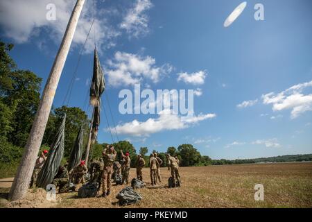 U.S. Army Rigger arbeiten mit fallschirmjägern aus Botswana, Italien und Südafrika ihre Fallschirme zu schütteln Nach einer Einarbeitung springen als Teil der Leapfest an der Universität von Rhode Island, West Kingston, R.I., Aug 2, 2018. Leapfest ist der größte und am längsten bestehende, internationale statische Linie Fallschirm Training und Wettbewerb veranstaltet vom 56. Truppe den Befehl, Rhode-Island Army National Guard hohen Niveau zu fördern technische und Korpsgeist innerhalb der internationalen Gemeinschaft in der Luft. Stockfoto