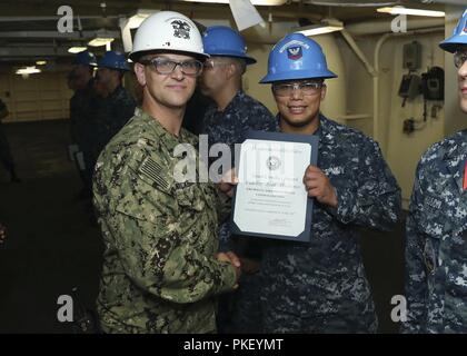 NEWPORT NEWS, Virginia (Aug. 2, 2018) Elektriker Mate 3. Klasse Jesus Jaramilloarroyo, aus Austin, Texas, auf USS Gerald R. Ford's (CVN 78) Engineering Abteilung zugewiesen, erhält eine gute Führung Medaille Zertifikat von Lt.Cmdr. Michael Knickerbocker, Hilfskräfte Ford's Officer, während der Preisverleihung auf Ford. Stockfoto