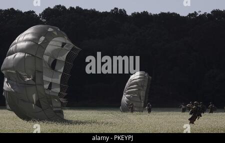 Fallschirmjäger abrufen ihre Fallschirme nach der Landung auf Schloss Drop Zone nach der Teilnahme an einem Einarbeitung springen als Teil der Leapfest an der Universität von Rhode Island, West Kingston, R.I., Aug 2, 2018. Leapfest ist der größte und am längsten bestehende, internationale statische Linie Fallschirm Training und Wettbewerb veranstaltet vom 56. Truppe den Befehl, Rhode-Island Army National Guard hohe technische Ausbildung zu fördern und Korpsgeist innerhalb der internationalen Gemeinschaft in der Luft. Stockfoto