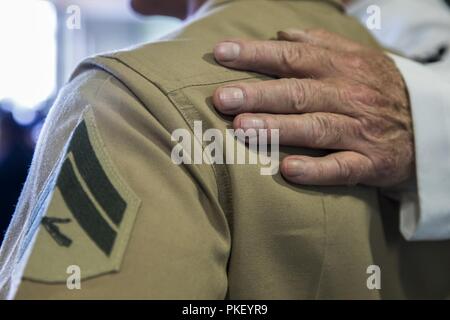 SEATTLE (August 3, 2018) Robert Imari, a U.S. Navy Veteran, legt seine Hand auf US Marine Corps Cpl. Andrew Licea, motorman mit 2Nd Battalion, 7th Marine Regiment, während Seafair Flotte Woche. Seafair Fleet Week ist eine jährliche Feier des Meeres Dienstleistungen darin Seemänner, Marinesoldaten und Küstenwache Mitglieder vom Besuch der US-Marine und Küstenwache Schiffe und Schiffe aus Kanada machen die Stadt zu einem Hafen des Anrufs. (U.S. Marine Corps Stockfoto