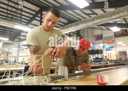 U.S. Army Staff Sgt. Brian Fox, zugeordnet zu den 139 Quartiermeister und SPC. Joshua Creech, zugeordnet zu den 338 Quartiermeister, der MC-6 Fallschirm verpacken in Gebäude 216, Fallschirm Rigger Facility Schuppen, während Leapfest 2018 West Kingston, RI., 3. August 2018. Leapfest ist der größte und am längsten bestehende, internationale statische Linie Fallschirm Training und Wettbewerb veranstaltet vom 56. Truppe den Befehl, Rhode-Island Army National Guard hohe technische Ausbildung zu fördern und Korpsgeist innerhalb der internationalen Gemeinschaft in der Luft. Stockfoto