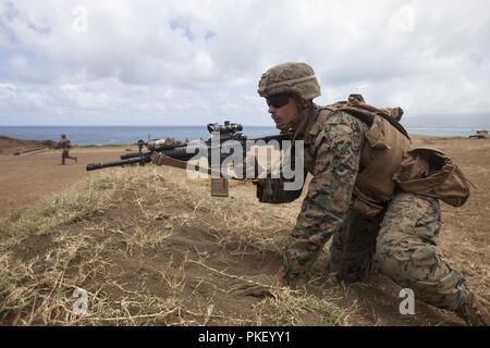 Us Marine Corps Lance Cpl. Wyatt Prettyman, einem truppführer mit Lima Company, 3.BATAILLON, 3. Marine Regiment, III Marine Expeditionary Force, bewegt sich vorwärts, während eine kombinierte Waffen Übung in der Kaneohe Bay Bereich Training Service, Marine Corps Base Hawaii, Aug 3, 2018. Während der Übung, U.S. Marines genutzt Maschinengewehr Unterdrückung und Mörtel Feuer auf simulierten feindlichen Kräfte, während die Infanteristen in Richtung sie angriff. Stockfoto