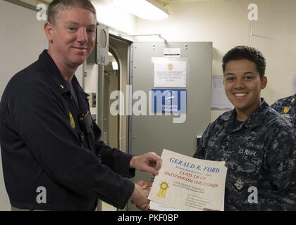 NEWPORT NEWS, Virginia (Aug. 3, 2018) Kulinarische Specialist Seaman Marissa Hodge, aus Denver, auf USS Gerald R. Ford's (CVN 78) Versorgung der Abteilung zugewiesen, erhält eine "hervorragende Führung" Award von Lt.Cmdr. Fred Masten, Sicherheit Ford's Officer, während eine in-port security Force (ISF) Klasse Graduierung. 20 - Neun Matrosen Graduierte der dreiwöchigen ISF-Kurs. Stockfoto