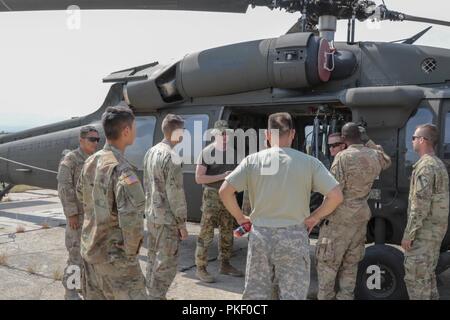 Georgia Armee nationale Scots Guards Chief Warrant Officer 2 Andrew J. Wilson, ein UH-60 Black Hawk pilot Alpha Company, 1.BATAILLON, 171St Aviation Regiment zugeordnet, führt eine Black Hawk Orientierung für Soldaten aus dem Fort Hood, Tx. Auf der Grundlage der 1.Kavallerie Division während der Noble Partner 18 am Wasiani, Georgien am Aug 3, 2018. Die troopers wurden leitende Orientierung Flüge der Ausbildung und Schulung zum richtigen Flugzeug laden Verfahren. Us-Armee Stockfoto